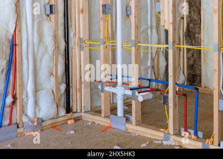 Construction d'une nouvelle maison construite avec des tuyaux de plomberie en plastique PEX à eau chaude et froide. Banque D'Images