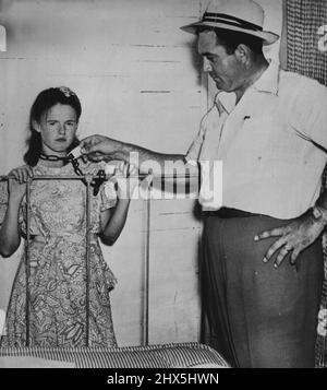 La femme agricole dit qu'elle était enchaînée -- Blanch Hamby (à gauche), femme agricole de 21 ans, montre l'enquêteur d'État San Allen la position dans laquelle elle dit qu'elle a souvent été enchaînée au pied de son lit pendant les deux années sine son mariage à Lester Bamby, 38. Le mari est dans la prison du comté de Tallapoosa, accusé d'agression avec intention de meurtre et d'agression et de batterie. 17 septembre 1948. (Photo par AP Wirephoto). Banque D'Images