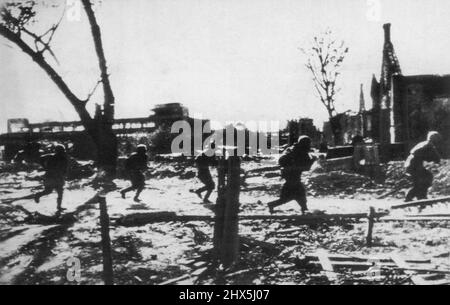 Les rouges rencontrent une attaque en temps double rapide -- au milieu de bâtiments épatés et de rues jonchées de débris, les soldats russes se courraient en avant pour rencontrer une attaque nazie lors des combats de rue dans la banlieue de Stalingrad. C'est une photo russe officielle. 26 novembre 1942. (Photo par AP Wirephoto). Banque D'Images