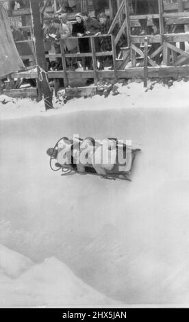 L'équipe de bobsleigh en fait une personne pointue - Joe Meconi et son équipe de bobsleigh négocient un virage en zigzag sur Mt. Le « Trial Mile » de Van Hoevenberg a eu lieu hier lors des épreuves olympiques de quatre hommes et des championnats nationaux senior de l'AUA. L'équipage est entré en finale d'aujourd'hui avec une légère avance après le temps de deux-chaleur d'hier de 2:15,50. 19 février 1947. (Photo par AP Wirephoto). Banque D'Images