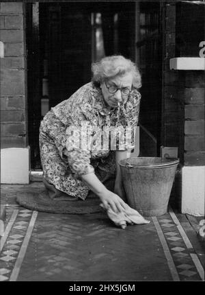 Pas fière - la Chambre est fière de l'épouse du ministre du Cabinet, mais elle n'est pas snob. Mme Emmanuel Shinwell, femme du ministre du carburant et de l'électricité, lavant le chemin de carrelage à l'entrée principale de la petite maison de Beechcroft Road, Tooting, Londres, où elle et son mari vivent. Mme Shinwell fait tous ses achats et travaux ménagers. Les Shinwells ont célébré leur anniversaire de mariage en 44th la semaine dernière. 18 octobre 1946. (Fonctions photo par miroir). Banque D'Images