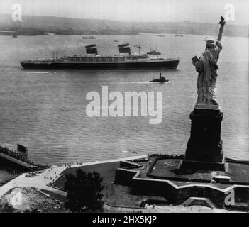 Miss Liberty Waves bon Voyage -- le plus récent et le plus grand paquebot de l'Amérique -- les Etats-Unis- passe devant la Statue de la liberté et se dirige vers la mer ouverte lors de son premier voyage en Europe hier. Le superpaquebot de 53 000 tonnes a transporté 1660 passagers sur ce qui pourrait être un passage record de l'océan Atlantique. Le record actuel vers l'est a été établi en 1938 par le paquebot britannique Queen Mary qui a fait le passage en trois jours, vingt heures et quarante-deux minutes. 4 juillet 1952. (Photo par AP Wirephoto). Banque D'Images