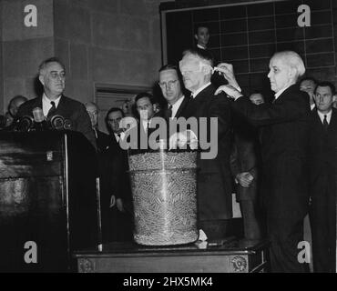 Stimson dessine la première capsule de brouillon -- la caméra enregistre un moment historique dans l'histoire des États-Unis en tant que secrétaire de la guerre Henry Stimson, aveuglés, tire le premier numéro de la première loterie de l'époque de la paix à Washington le 29th octobre. Le président Roosevelt regarde à gauche et le colonel Charles R. Morris, à la retraite, qui a pris les yeux bandés sur les responsables de la première Guerre mondiale, est à l'épaule du secrétaire Stimson. Le nombre tiré par Stimson était de 158. 29 octobre 1940. (Photo d'ACME). Banque D'Images