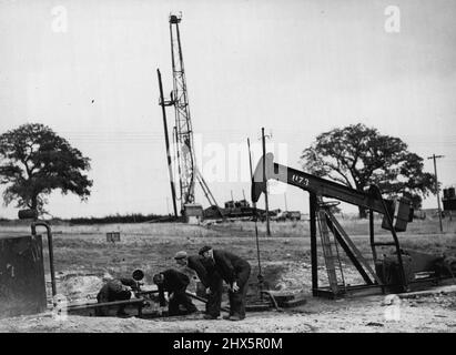 Champ pétrolifère secret de Britains. -- hommes au travail reliant une pompe, en arrière-plan un nouveau puits s'ennuie. Un champ pétrolier britannique, dont l'emplacement doit encore être gardé secret, produit du pétrole au rythme de 100 000 tonnes par an. Les experts qui ont foré pour le pétrole en Perse sont parmi les 1 000 travailleurs de ce village autrefois calme. L'huile est pompée à la surface par de petites pompes électriques sans bruit qui ne prennent que quelques quartiers carrés d'espace, et sont camouflés pour s'adapter à la campagne environnante. 16 janvier 1945. (Photo de London News Agency photos). Banque D'Images
