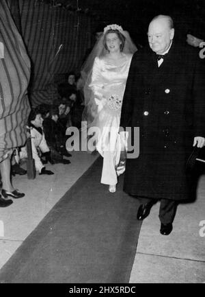 La fille de Winston Churchill Weds -- Mlle Mary Churchill, la mariée, arrive à St. Margaret's, Westminster pour son mariage cet après-midi le 11 février, accompagnée de son père, M. Winston Churchill. Notez que les spectateurs se pichent sous le ciel. 11 février 1947. (Photo par photo de presse associée). Banque D'Images