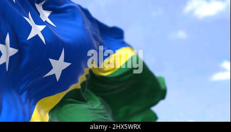 Détail du drapeau national des îles Salomon agitant dans le vent par temps clair. Les Îles Salomon sont un pays souverain en Océanie. Mise au point sélective. Banque D'Images