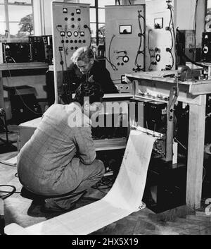 Le plus grand radiotélescope au monde - conçu et construit par des membres des laboratoires de physique de l'Université de Manchester, à la station expérimentale de Jodrell Bank à Chesshire. Ici, M. K. Das Gujula, de Calcutta, et M. R.C.Jennison, étudient les enregistrements réalisés à partir des résultats obtenus par les antennes de l'interféromètre solaire. 21 décembre 1951. (Photo par British Official Photograph). Banque D'Images