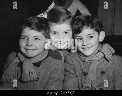 Les « triplés de Kenton » vont en Tasmanie -- trois jeunes migrants, les triplés de Tonelly, âgés de sept ans (de gauche à droite) Paul, Julia et Peter - photographiés à la gare de Waterloo, Londres, avant d'embarquer aujourd'hui dans le train à bateaux « Malaja » pour l'Australie (jeudi). Né il y a sept ans à la Saint-Valentin, ils viennent de Kenton, Middlesex, et vont avec leurs parents s'installer dans le nord de la Tasmanie. M. Walter Tonelly, le père, a été le maître de bétail du comte de Wilton, à Woodstock, à Oxford. Il le fera Banque D'Images