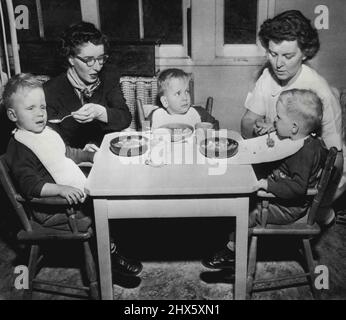 Les triplés aveugles déjeunent - les triplés aveugles Harry, Larry et Barry Terry (de G à D) de Stearns, Kentucky., déjeunent pour la première fois à la pépinière de Boston pour les bébés aveugles. Les tots, qui auront trois ans dimanche, sont arrivés ici la nuit dernière pour commencer un cours de formation de trois ans financé par des amis du Kentucky. Miss Mildred Sloan, qui a accompagné des enfants du Kentucky, est à gauche. L'infirmière Amelia S. Reed du personnel de la pépinière est à droite. Les médecins ici examineront les garçons, aveugles depuis la naissance, pour voir s'il y en a Banque D'Images