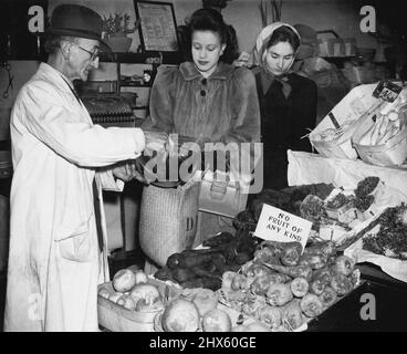 London Housewife 1946. Les pommes de terre sont généralement abondantes: Juste le long de la route de, la MRS du épicier (Jill reçoit 71b. De pommes de terre de son greengrocer, M. Ferraro, "aucun fruit de n'importe quel genre" dit la carte (toutes les cartes disent "non"), ce que Mme Gill attendait. Les oranges sont nouvelles tous les quelques mois ; les bébés peuvent obtenir une livre sur leurs livres de ration verte et ce qui reste va aux adultes, la première chiploade de bananes (une demi-livre pour les moins de quatre-vingts) vient d'arriver à Londres. 12 juillet 1950. (Photo Banque D'Images