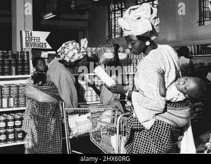Les achats en libre-service ont récemment été introduits dans certains magasins ian. Ici, dans un magasin à Lagos, une mère, avec son bébé attaché solidement à son dos, fait le shopping de la journée dans le style européen moderne. 02 mars 1955. (Photo de Daily Mirror).;les achats en libre-service ont récemment été introduits dans certains magasins ian. Ici, dans un magasin à Lagos, une mère, avec son bébé attaché solidement à son dos, fait le shopping de la journée dans le style européen moderne. Banque D'Images