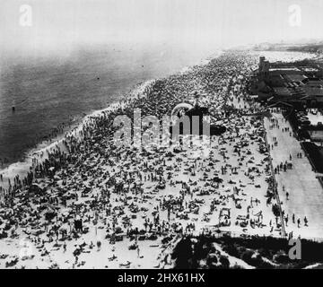 New Yorkers Flock to Beach - Un hélicoptère de la police survole le parc bondé Jacob Riis dans le Queens ici hier, alors que les températures de 90 degrés plus ont été inaugurées en été et a envoyé des trongs se faubourer sur les plages. L'hélicoptère effectue des patrouilles dans la zone pour empêcher les bateaux à moteur de s'approcher trop près de la rive. 22 juin 1953. (Photo par AP Wirephoto).;New Yorkers Flock to Beach - Un hélicoptère de police survole le parc bondé Jacob Riis dans les Queens, ici hier, alors que les températures de 90 degrés plus ont été inaugurées en été et a envoyé des grondements Banque D'Images