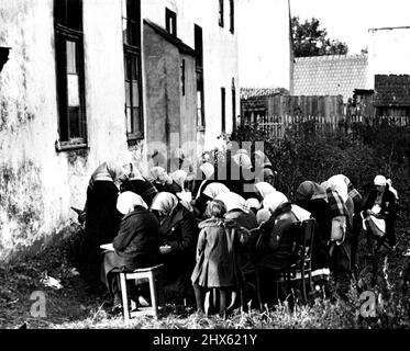 Tandis que le culte des hommes: Femmes-Folk attendent dehors -- la scène est à Mukacheve, chef de plusieurs villages presque exclusivement juifs dans ce qui était autrefois la Russie carpatique. Un grand mélange racial prévaut dans le district, sept langues différentes sont parlées. C'est selon les principes orthodoxes, aucun lieu n'étant réservé aux femmes dans la synagogue. Dans les synagogues modernes (ainsi que dans certaines églises protestantes comme le luthérien, par exemple), les femmes et les hommes sont assis séparés, mais parmi les strictement orthodoxes, Banque D'Images