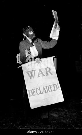 Le test de précautions le plus réaliste des aides aériennes de Londres - Un jeune garçon portant un mas à gaz vendant des papiers pour dire la guerre est Deolared, - l'une des nombreuses touches réalistes. L'une des démonstrations de prévention de raid aérien les plus réalistes à ce jour a été produite par le conseil de quartier de Kensington, hier soir. Pour ce faire, un grand terrain de déchets en face d'Olympia dans Kensington High Street a été converti en un théâtre en plein air avec 4 000 sièges gratuits pour le public. 27 mai 1938. (Photo de Keystone).;les plus de Londres Banque D'Images