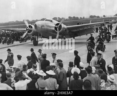 Hughes termine le Globe Circle -- Voici le monoplan d'argent qui gironne le monde entier du vol de Howard Hughes dans le monde entier alors qu'il était en taxi à l'aéroport de Floyd Bennett, New York City, juillet 14. Un groupe de New-Yorkais excités étaient sur place pour saluer les cinq aviateurs inspirés à bord. 14 juillet 1938. (Photo par photo de presse associée). Banque D'Images