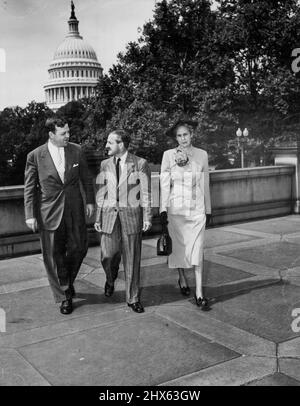 Harold Leslie White, bibliothécaire du Commonwealth d'Australie, est aux États-Unis pendant trois mois pour observer les bibliothèques, les universités et les collèges et pour discuter avec des collègues dans son domaine. Sa visite est rendue possible grâce à une subvention accordée par le département d'État des États-Unis dans le cadre de son programme d'échange de personnes. La photographie, faite à la Bibliothèque du Congrès des États-Unis à Washington, D.C., montre M. White (Centre) avec le Dr. Luther Evans, bibliothécaire du Congrès des États-Unis, et Mme White. Dans le gr. Arrière Banque D'Images