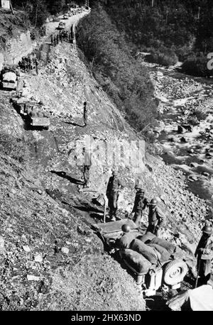 Escalade d'une montagne en Italie : en travaillant sur une route de montagne récemment réparée au sud-ouest de Bologne, en Italie, les jeeps et les camions américains passent devant les troupes américaines qui se tiennent debout pour aider tout véhicule qui traîne. Les hommes et les véhicules font partie de la Cinquième Armée alliée, qui se dirige lentement vers Bologne, sur un terrain boueux et révolutionnaire à la fin octobre 1944. Les Allemands avaient massé l'artillerie et avaient érigé des barrières supplémentaires en barbelés, pour entraver davantage l'avancée. 22 novembre 1944. (Photo des Etats-Unis Banque D'Images