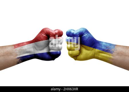 Deux mains poinçonner l'une à l'autre sur fond blanc. Drapeaux de pays peint les poings, le concept de crise de conflit entre les pays-bas et l'ukraine Banque D'Images