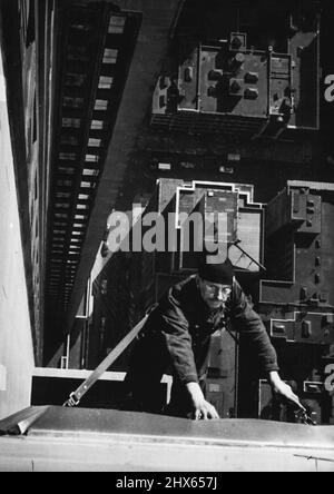 L'Empire State Building dispose de 6,4000 fenêtres, et leur nettoyage permet à un personnel de 7 hommes de s'occuper tous les jours. Cette photo, prise à partir d'une remise en place sur le 81st étage, montre Richard Hart, contremaître de l'équipe de 7 hommes, qui nettoie une fenêtre au-dessous du 80th étage. HART, né dans l'État du Maine, mais résident de Staten Island, l'un des cinq quartiers de New York, est un nettoyeur de fenêtres depuis environ 30 ans, et a nettoyé les fenêtres de l'Empire State depuis son ouverture en 1931. Des hauteurs de m Banque D'Images