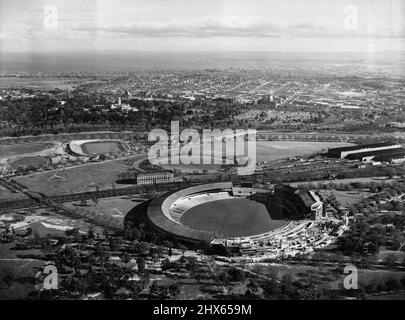 Vue aérienne des principaux sites du match olympique de Melbourne : le stade principal des Jeux Olympiques de 1956, le terrain de cricket de Melbourne, au premier plan, avec le parc olympique, centre sportif moderne où se jouent la natation, la plongée, le vélo, le football et le hockey. Le fleuve Yarra traverse les parcs de la ville jusqu'à la baie de Port Phillip. Melbourne, en Australie, sera la ville hôte des Jeux Olympiques de 1956. Les visiteurs et les concurrents olympiques trouveront une cité moderne et gracieuse de 1,5 Banque D'Images