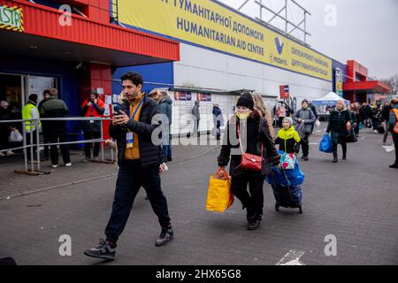 Przemysl, Pologne. 09th mars 2022. Un volontaire a été vu pour conduire les réfugiés vers leur prochaine destination.Un centre temporaire d'accueil des réfugiés a été installé dans un ancien entrepôt de Tesco à la périphérie de Przemy?l pour abriter des centaines de milliers de réfugiés ukrainiens qui fuient par la frontière entre Medyka et Shehyni. Crédit : SOPA Images Limited/Alamy Live News Banque D'Images