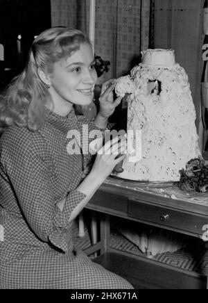 Ce gâteau est fait de 100 œufs... voir ? -- l'actrice Mai Zetterling coupe le premier morceau de gâteau, montrant la bougie allumée à l'intérieur. L'actrice suédoise Maï Zetterling a eu l'honneur de couper et de goûter la première tranche d'un gâteau traditionnel suédois de mariage ou d'anniversaire, composé d'environ 100 œufs, qui a été envoyé de Suède par mer pour l'exposition 'Scandinavia at Table' au Tea Centre Dans Regent Street à Londres. Le gâteau de deux pieds de haut a un centre creux dans lequel un léger Banque D'Images