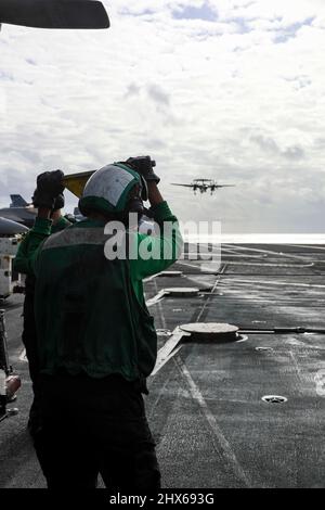 MER DES PHILIPPINES (9 mars 2022) Aviation Boatswain’s Mate (Equipment) Airman Jakory Lewis, à gauche, de la Nouvelle-Orléans, observe les opérations de vol sur le pont de vol du porte-avions de la classe Nimitz USS Abraham Lincoln (CVN 72). Abraham Lincoln Strike Group est en cours de déploiement prévu dans la zone d'exploitation de la flotte américaine 7th afin d'améliorer l'interopérabilité par le biais d'alliances et de partenariats tout en servant de force d'intervention prête à l'emploi pour soutenir une région Indo-Pacifique libre et ouverte. (É.-U. Photo de la marine par le Spécialiste des communications de masse 3rd classe Javier Reyes) Banque D'Images