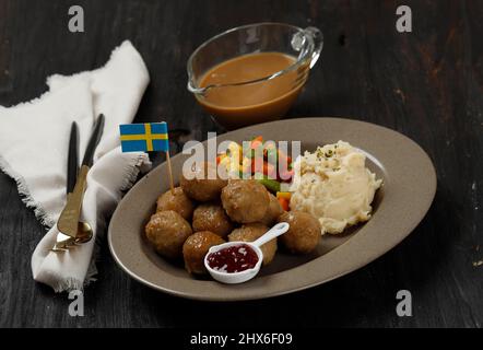 Boulettes de viande traditionnelles suédoises avec purée de pommes de terre et sauce aux canneberges. Concept alimentaire suédois. Sur une table en bois Banque D'Images