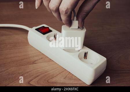 Prise femelle pour brancher le câble usb à la main dans l'adaptateur du chargeur de téléphone. Banque D'Images