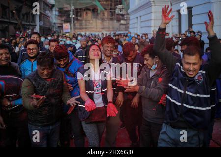 Bhaktapur, Bagmati, Népal. 10th mars 2022. Le dévot népalais célèbre en lançant de la poudre colorée, après que des membres de Manandhar Guthi érigent des bambou cérémoniels connu sous le nom de Chir avec les bandes de tissu vibrantes, qui représentent les charmes de bonne chance, le premier jour de la célébration Holi, les festivals de couleurs à la place Basantapur Durbar, Katmandou, Népal. (Image de crédit : © Amit Machamasi/ZUMA Press Wire) Banque D'Images