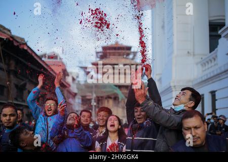 Bhaktapur, Bagmati, Népal. 10th mars 2022. Le dévot népalais célèbre en lançant de la poudre colorée, après que des membres de Manandhar Guthi érigent des bambou cérémoniels connu sous le nom de Chir avec les bandes de tissu vibrantes, qui représentent les charmes de bonne chance, le premier jour de la célébration Holi, les festivals de couleurs à la place Basantapur Durbar, Katmandou, Népal. (Image de crédit : © Amit Machamasi/ZUMA Press Wire) Banque D'Images