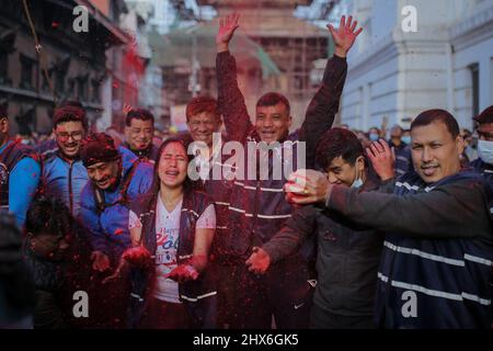 Bhaktapur, Bagmati, Népal. 10th mars 2022. Le dévot népalais célèbre en lançant de la poudre colorée, après que des membres de Manandhar Guthi érigent des bambou cérémoniels connu sous le nom de Chir avec les bandes de tissu vibrantes, qui représentent les charmes de bonne chance, le premier jour de la célébration Holi, les festivals de couleurs à la place Basantapur Durbar, Katmandou, Népal. (Image de crédit : © Amit Machamasi/ZUMA Press Wire) Banque D'Images