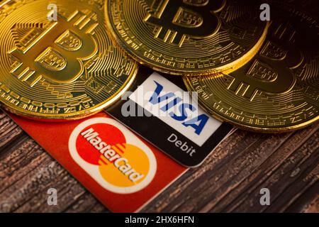 Bayan Lepas, Penang, Malaisie - janvier 2 2022 : Bitcoin doré avec logo Visa et Mastercard sur fond de bois. Monnaie numérique. Banque D'Images