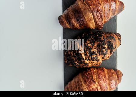 trois croissants sur un plateau noir vue sur le dessus Banque D'Images