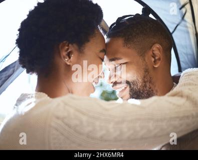 Vous êtes ma maison loin de chez vous. Photo d'un jeune couple passant du temps ensemble dans leur tente pendant le camping. Banque D'Images