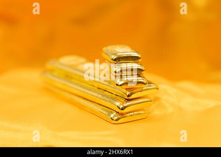piles de longues et courtes barres d'or pur sur fond doré. Mise au point sélective Banque D'Images