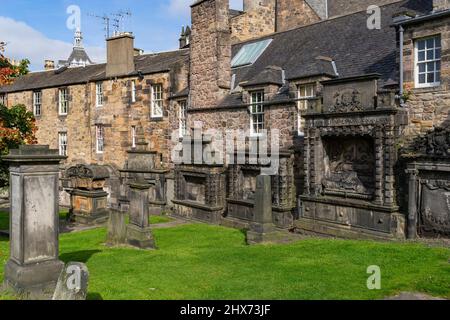 Détail de vieilles pierres de tête contre le mur des maisons face à Candlemaker Row et sur les parcelles individuelles au cimetière de Greyfriars à Édimbourg. Banque D'Images