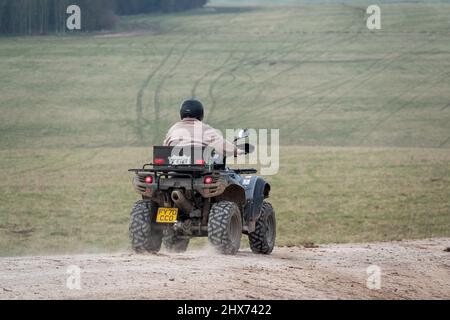 un quad avec des lumières sur la conduite de son quad hors-route le long d'une piste de pierre campagne ouverte Banque D'Images