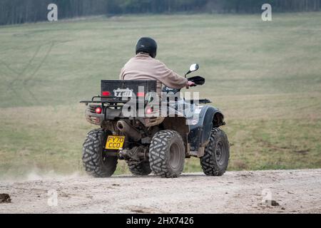 un quad avec des lumières sur la conduite de son quad hors-route le long d'une piste de pierre campagne ouverte Banque D'Images