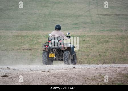 un quad avec des lumières sur la conduite de son quad hors-route le long d'une piste de pierre campagne ouverte Banque D'Images