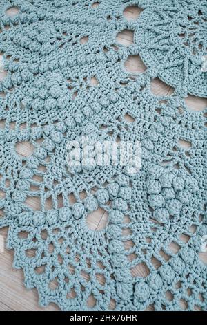 Tapis maison tricoté de fils épais, fait à la main: Un tapis fait à la main de fils bleus se trouve sur le sol, l'art du tricotage Banque D'Images