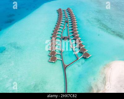 Villas sur l'eau et plage de sable blanc sur l'île de l'atoll tropical pour les vacances voyage de vacances et lune de miel. Hôtel de luxe aux Maldives ou Caribbea Banque D'Images