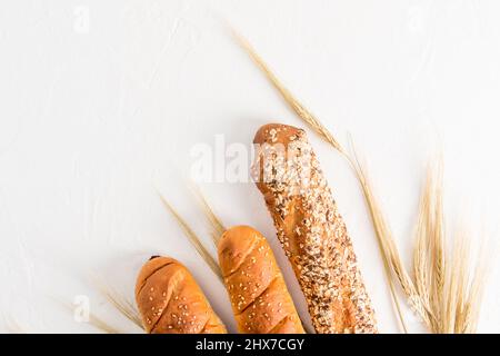 trois morceaux de baguette hachée sur fond blanc avec épis de blé. vue du dessus. fond blanc. une copie de l'espace Banque D'Images