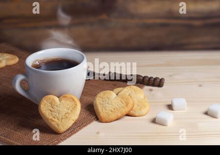 Tasse de café et biscuits sablés en forme de coeur sur table en bois Banque D'Images