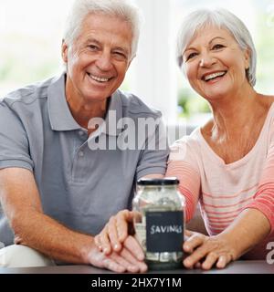 Un pot de bonheur et de sécurité. Photo d'un couple senior posant avec son pot d'épargne. Banque D'Images