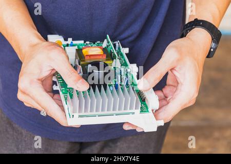 Technicien tenant la carte électronique de l'ordinateur dans la main. Banque D'Images