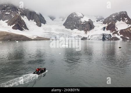 Les touristes et les guides voyagent dans un bateau gonflable zodiac pour visiter un glacier à Hornsund, Spitsbergen, Svalbard Banque D'Images