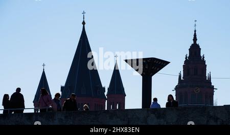 Mayence, Allemagne. 10th mars 2022. Les gens se tiennent au soleil sur la place devant l'hôtel de ville et la Rheingoldhalle, sur fond de la cathédrale de Mayence dont les tours sont visibles en arrière-plan. Credit: Frank Rumpenhorst/dpa/Alay Live News Banque D'Images