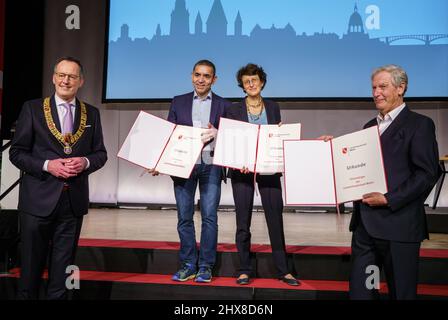 Mayence, Allemagne. 10th mars 2022. Le Lord maire de Mayence, Michael Ebling (l), est sur scène lors de l'attribution de la citoyenneté honoraire de la ville de Mayence aux scientifiques Ugur Sahin (2nd de gauche), zlem Türeci (2nd de droite) et Christoph Huber (r). Huber a été chef de la clinique médicale, hématologie et oncologie à l'Université de Mayence lorsqu'il a fondé la société BioNTech basée à Mayence avec Sahin et Türeci en 2008. Credit: Frank Rumpenhorst/dpa/Alay Live News Banque D'Images