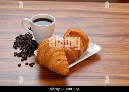 Une tasse de café et deux croissants est un bon début de journée. Petit déjeuner continental Banque D'Images